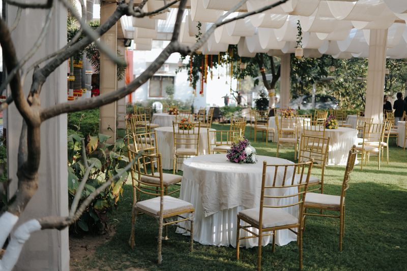 Garden seating laid out under draped canopies before a wedding function