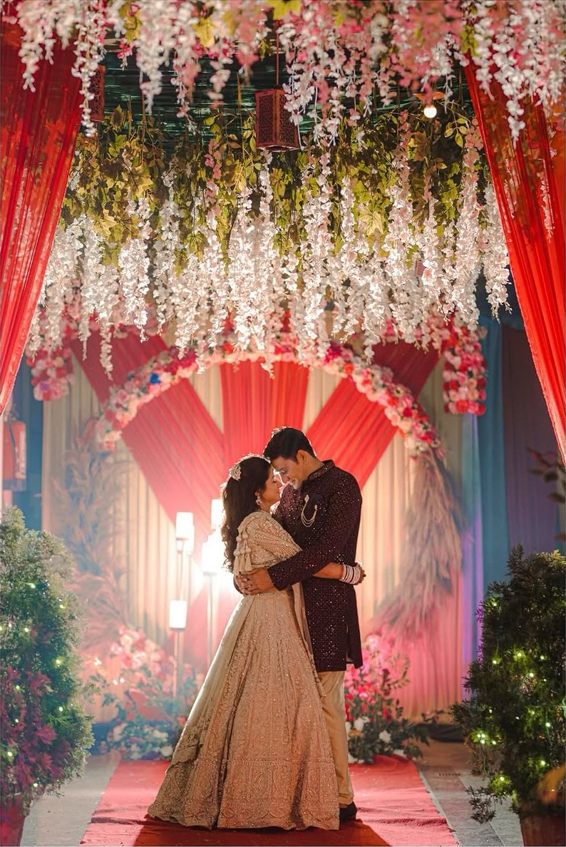 A couple beneath a canopy of hanging blossoms